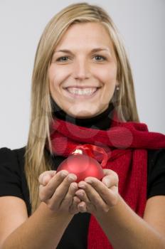 Royalty Free Photo of a Woman Holding an Ornament in the Palms of Her Hands