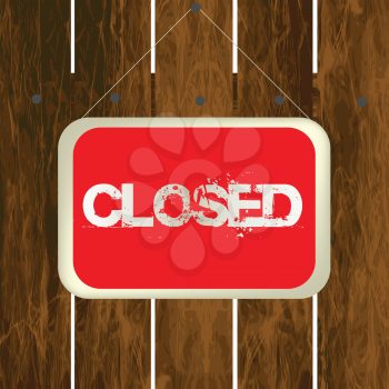 Closed sign hanging on a wooden fence