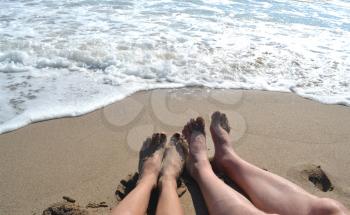 Male and female legs on the beach
