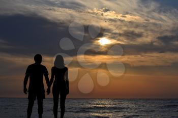 Lovers silhouettes at sunrise at seaside