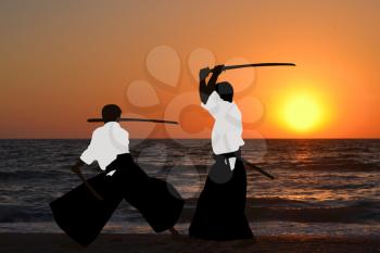 Men practicing Aikido at sunrise