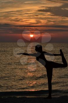 Warrior pose from yoga by woman silhouette on sunrise