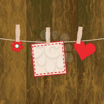 Note paper, flower and heart on the wooden background with clothespins