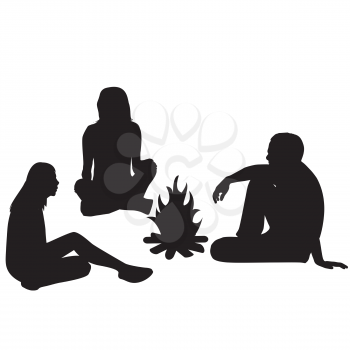 Silhouettes of tourists sitting around a campfire