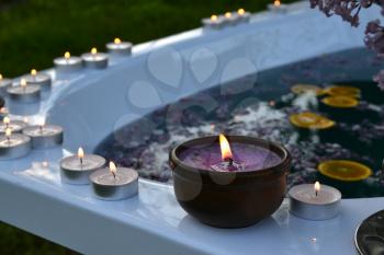 Relax backgroand with candles on the edge of a bathtub