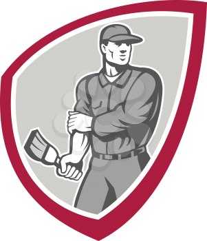 Illustration of a house painter with paintbrush rolling up sleeves facing front set inside shield crest done in retro style on isolated background.
