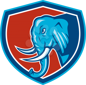 Illustration of an elephant head with tusks viewed from the side set inside shield crest on isolated background done in cartoon style.