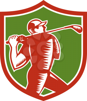 Illustration of a golfer playing golf swinging club tee off viewed from the side set inside shield crest on isolated background done in retro woodcut style.