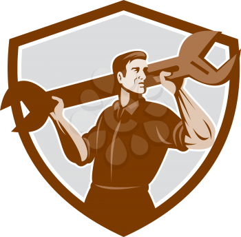 Illustration of a mechanic lifting giant spanner wrench viewed from front set inside shield crest on isolated background done in retro style. 