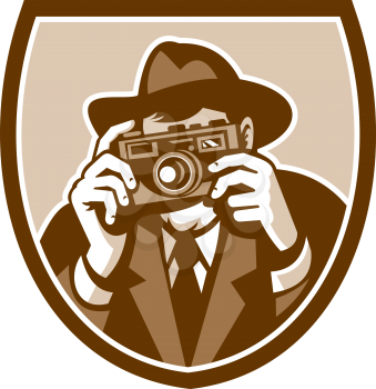 Illustration of a photographer shooting aiming with vintage camera facing front set inside shield crest on isolated background done in retro style. 