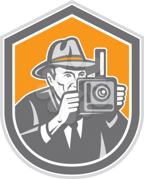 Illustration of a photographer wearing fedora hat shooting with vintage bellows camera set inside shield crest on isolated background done in retro style.