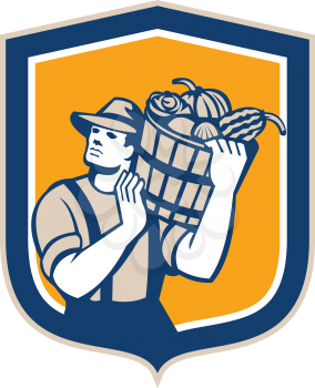 Illustration of wheat farmer carrying bucket basket with crops produce harvest on shoulder looking to the side set inside shield crest shape on isolated background done in retro style.