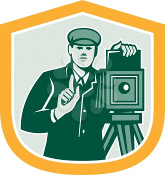Illustration of a photographer shooting with vintage bellows camera viewed from the front set inside shield crest on isolated white background done in retro style. 