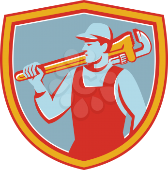 Illustration of a plumber holding monkey wrench on shoulder looking to the side set inside shield crest on isolated background done in retro style. 