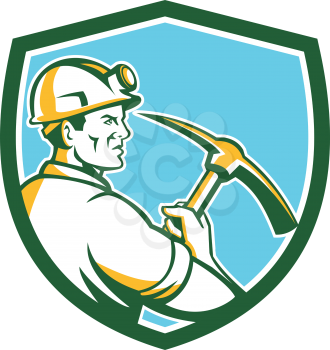 Illustration of a coal miner wearing hardhat with light lamp holding crossed pick axe viewed from the side set inside shield crest on isolated background done in retro style.