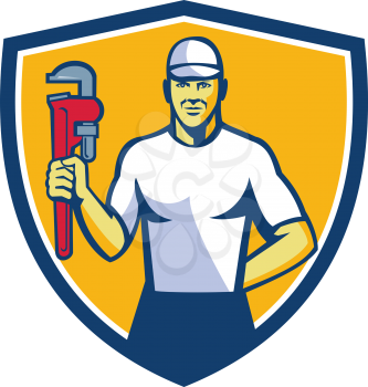 Illustration of a plumber wearing hat holding monkey wrench facing front set inside shield crest on isolated background done in retro style. 