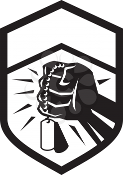 Illustration of a clenched fist clutching holding dogtag set inside shield crest done in black and white retro style. 