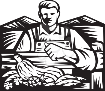 Black and white illustration of organic farmer with crop produce harvest of vegetable facing front on fence with farm field and mountains and thumbs up in background done in retro woodcut style. 
