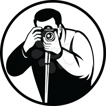 Black and white retro style illustration of a photographer shooting with digital slr camera viewed from front set inside circle on isolated background.