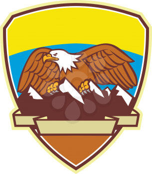 Mascot icon illustration of an American Bald Eagle perching on top of snow capped mountain range set inside crest or shield viewed from front on isolated background in retro style.