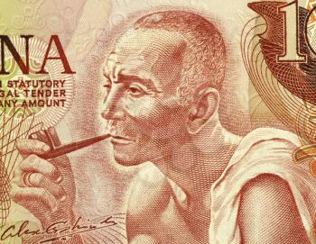 Royalty Free Photo of a Man Smoking a Pipe on 10 cedis 1978 Banknote from Ghana.