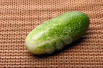Royalty Free Photo of a Cucumber on a Braided Mat