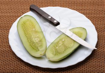 Royalty Free Photo of a Pickle Sliced in Half on a Plate