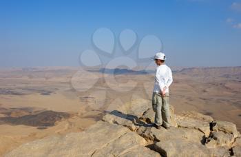 Royalty Free Photo of a Boy at the Edge of a Crater in the Desert