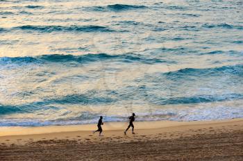 Royalty Free Photo of People Jogging on the Beach of the Mediterranean Sea