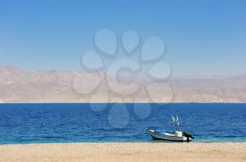 Royalty Free Photo of the Gulf of Eilat Red Sea, With a Boat on the Shore and the Jordanian Mountains in the Background