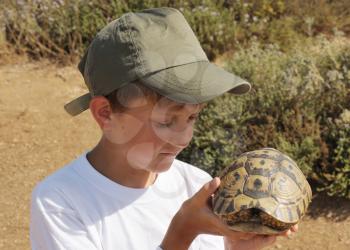 Royalty Free Photo of a Boy Looking at a Turtle
