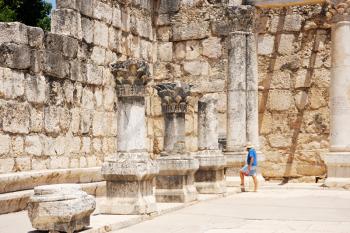 Royalty Free Photo of a Woman at the Ruins of an Ancient Roman Temple in the town of Capernaum (Galilee, Israel)