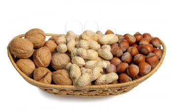 Walnuts, hazelnuts and peanuts in a wicker basket on a white background, isolated