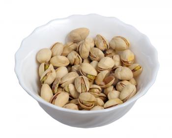 Pistachios on a plate on a white background, isolated