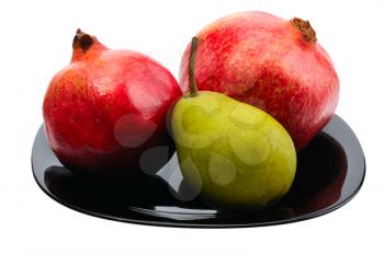 Royalty Free Photo of Two Pomegranates and a Pear on a Black Plate