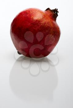 Royalty Free Photo of a Pomegranate Reflected on White