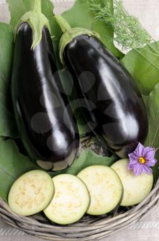 Royalty Free Photo of Two Eggplants and Slices in a Basket