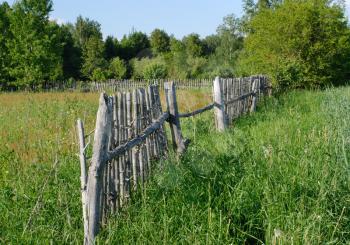 Royalty Free Photo of a Rural Landscape in Summer With a Fence in a Field
