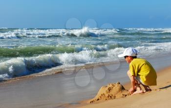 Royalty Free Photo of a Boy Playing in the Sand at the Seashore