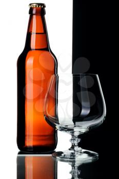 Bottle of beer and glass, isolated on a black and white background.