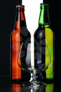 Bottles of lager beer from green and brown glass, isolated on a black and white background.