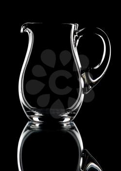 Glass pitcher on a black background, isolated