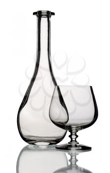 Glass bottle and goblet, isolated on a white background.
