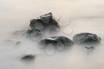 Stones in the lake early morning, wet from the rolling waves. 