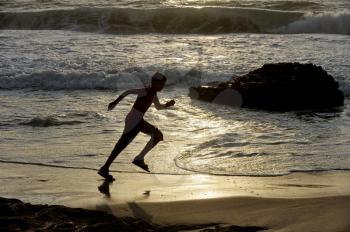 Boy runs along the shore of the Mediterranean Sea in Israel