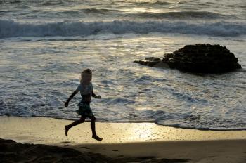 Girl runs along the shore of the Mediterranean Sea in Israel