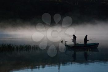 Fishermen in the foggy lake