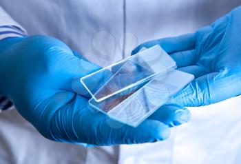 Scientist holding frosted glass microscope slides