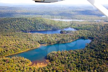 Adirondack forests, lakes, creeks and mountains aerial terrain view down from light aircraft