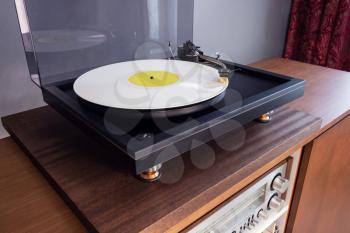 Vintage Stereo Turntable Plays White Vinyl Record Album, angled view